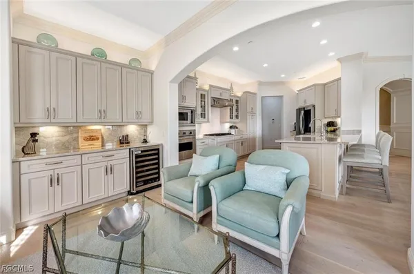 a kitchen with a dining table chairs cabinets and stainless steel appliances