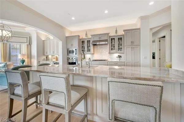 a large white kitchen with stainless steel appliances granite countertop a sink and cabinets