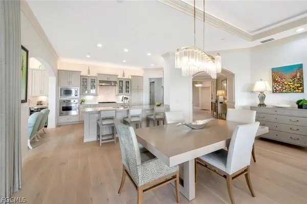 a view of a dining room and livingroom with furniture wooden floor a chandelier