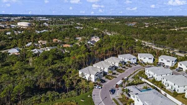 238 Osprey Preserve Boulevard Stuart, FL 34994 - Photo 28 of 31 an aerial view of residential houses with outdoor space and trees