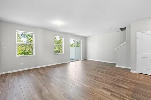 a view of an empty room with closet and a window