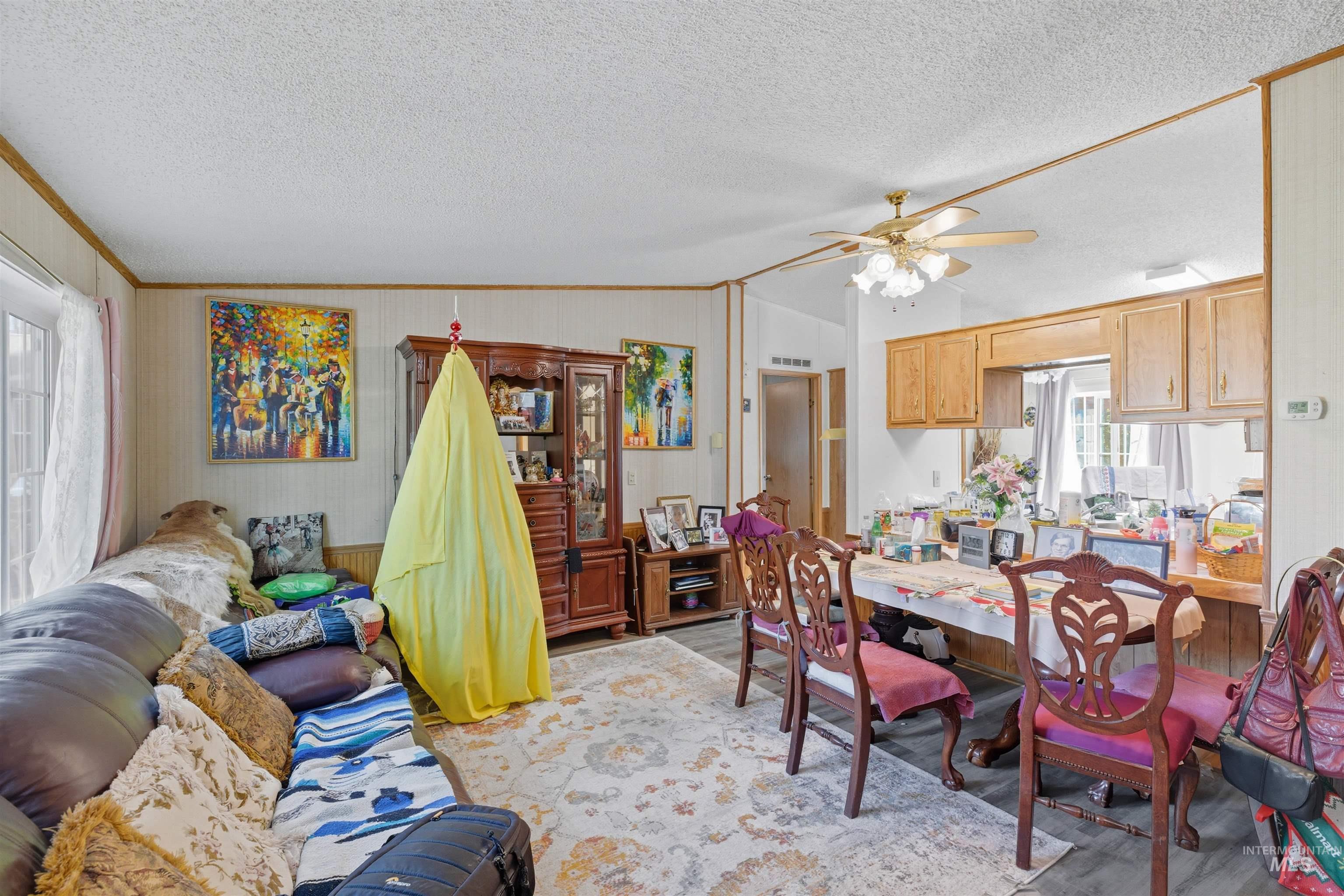 300 Main Street Deary, ID 83823 - Photo 4 of 18 Dining space featuring wood finished floors, a textured ceiling, lofted ceiling, a ceiling fan, and wooden walls
