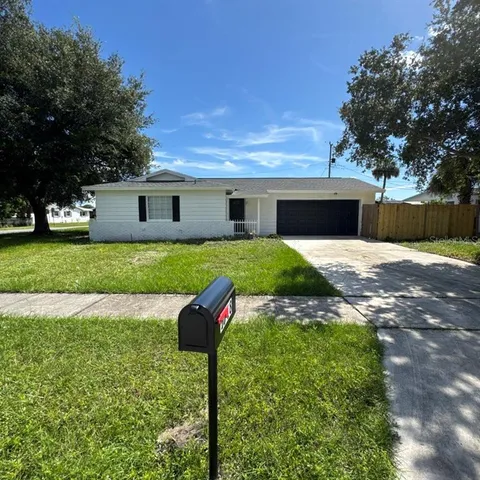 a view of house with backyard and trees