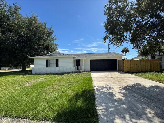 a front view of house with yard and trees
