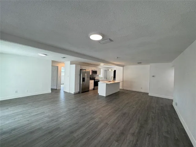 a view of a big room with wooden floor and windows