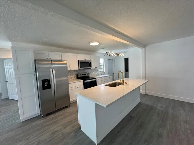 a kitchen with sink a microwave and refrigerator