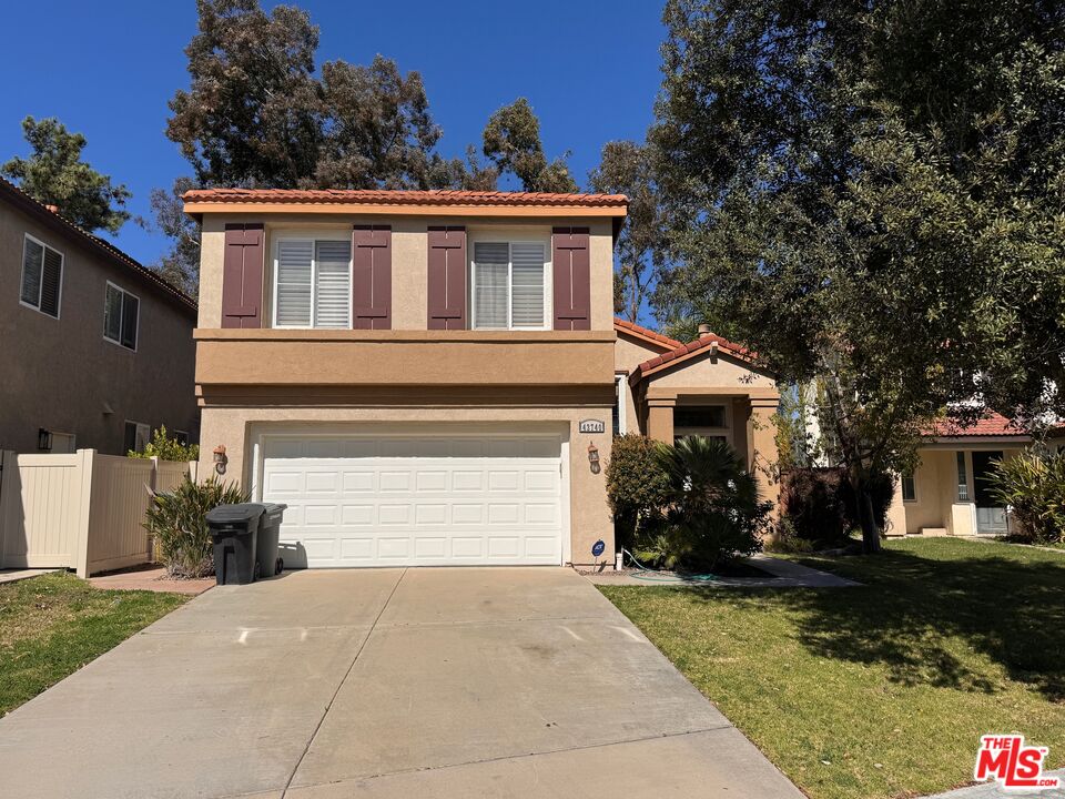 a front view of a house with a yard and a garage
