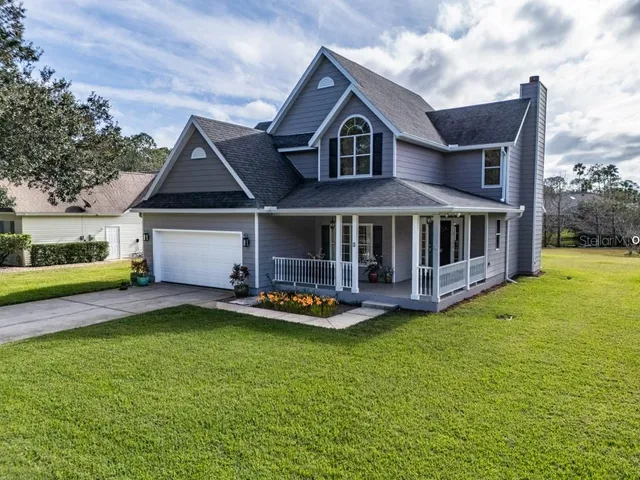 a front view of a house with yard and green space