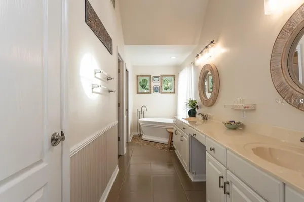 a view of a hallway with wooden floor and a bathroom