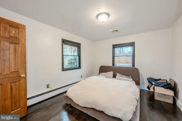 a bedroom with a bed and wooden floor