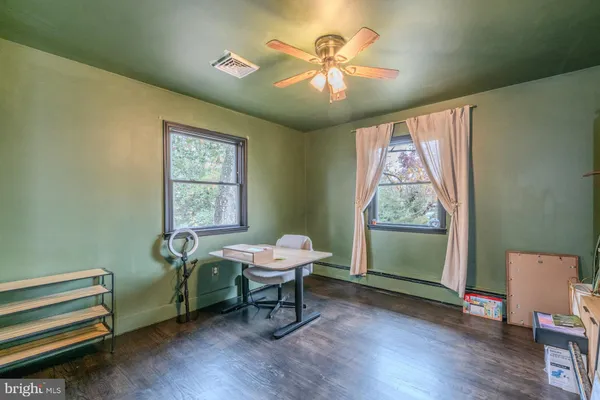 a workspace with wooden floor and a window