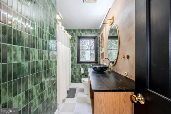 a bathroom with a granite countertop sink a mirror and shower