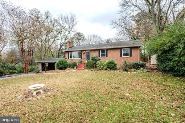 a front view of house with yard and trees around