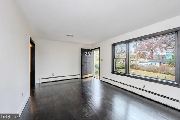 wooden floor in an empty room with a window