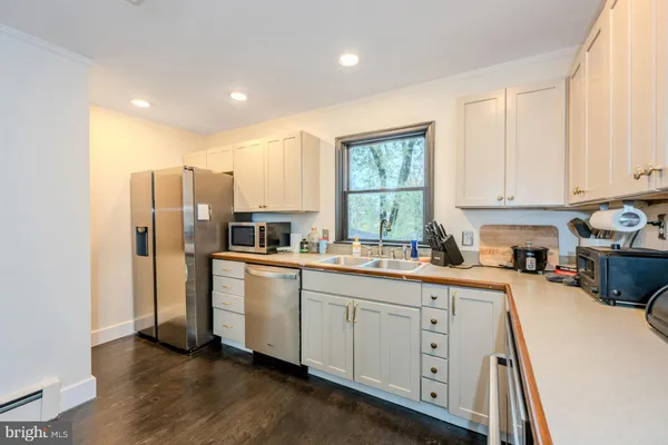 a kitchen with a sink a window and cabinets