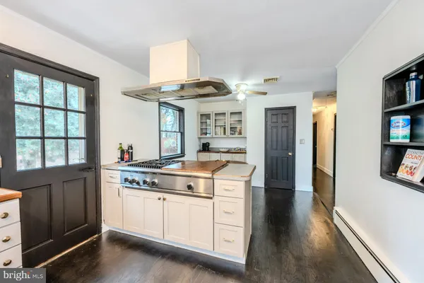 a kitchen with a stove and a wooden floors