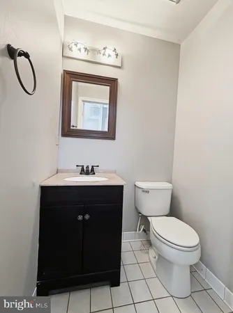 a bathroom with a toilet sink vanity and mirror