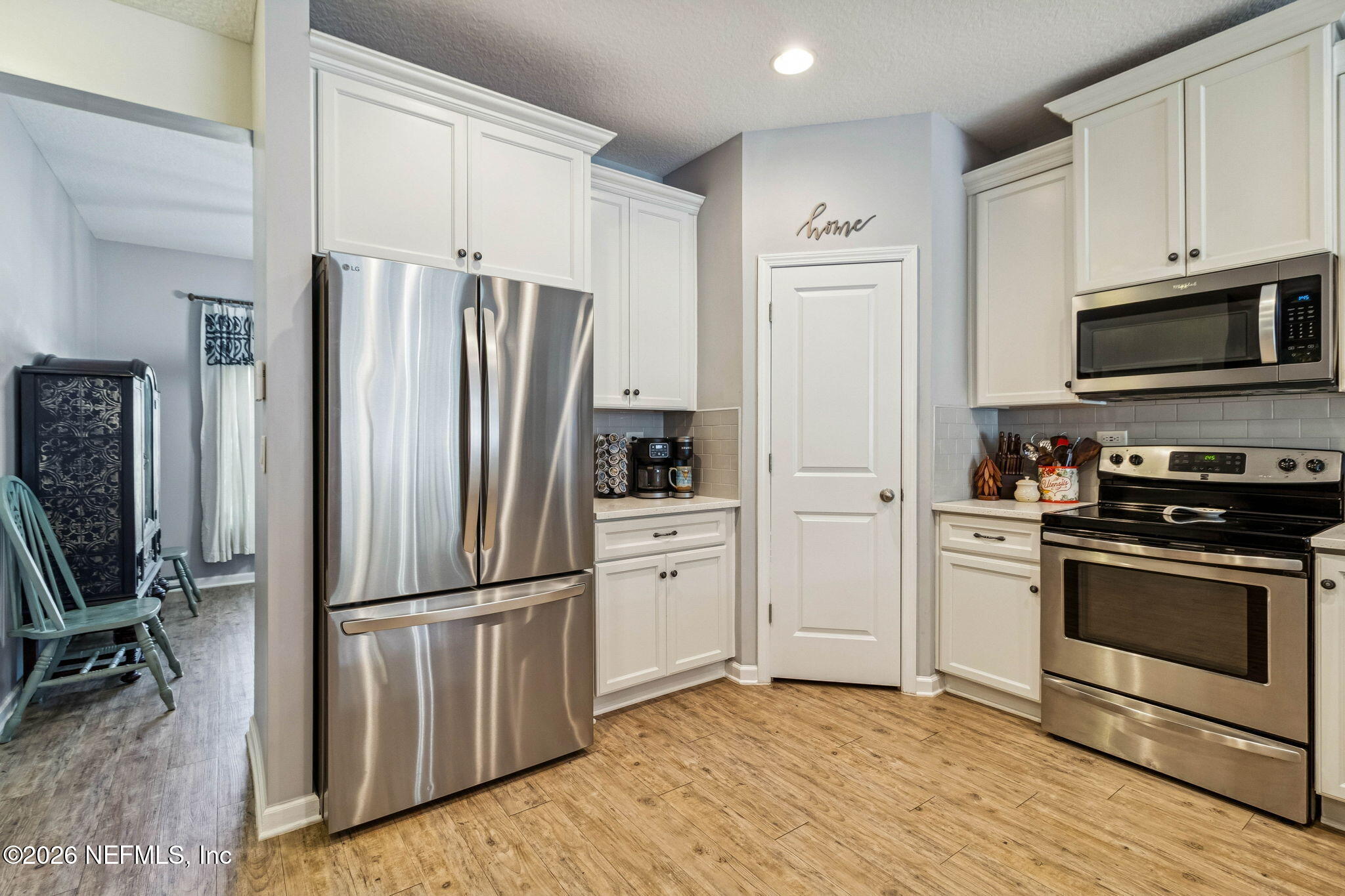 96048 Breezeway Court Yulee, FL 32097 - Photo 12 of 26 a kitchen with granite countertop a refrigerator stove and microwave