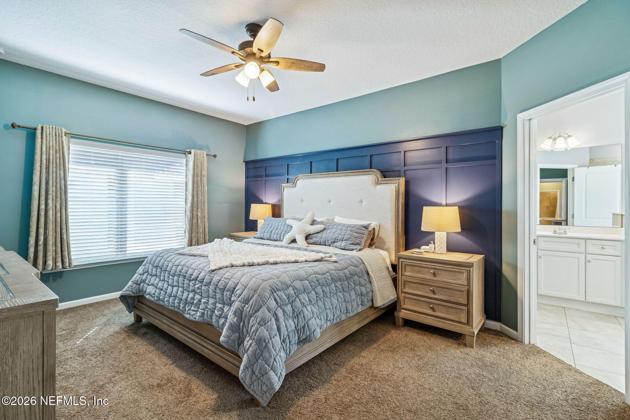 96048 Breezeway Court Yulee, FL 32097 - Photo 16 of 26 a bedroom with a bed and a chandelier