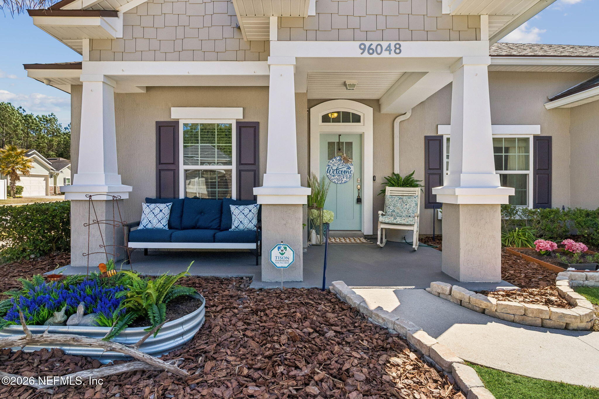 96048 Breezeway Court Yulee, FL 32097 - Photo 2 of 26 a front view of a house with outdoor seating and plants