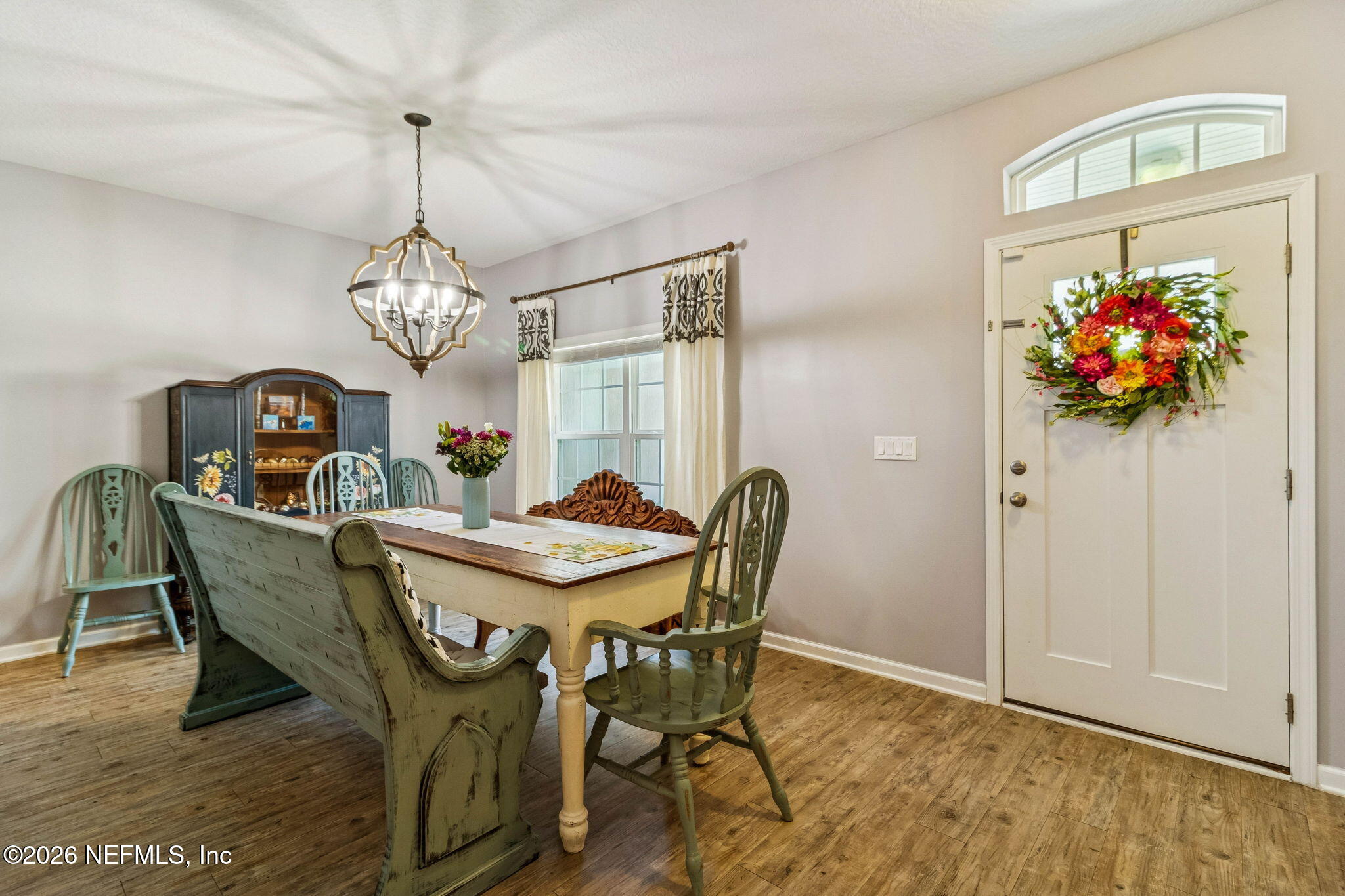 96048 Breezeway Court Yulee, FL 32097 - Photo 23 of 26 a view of a dining room with furniture a chandelier and wooden floor