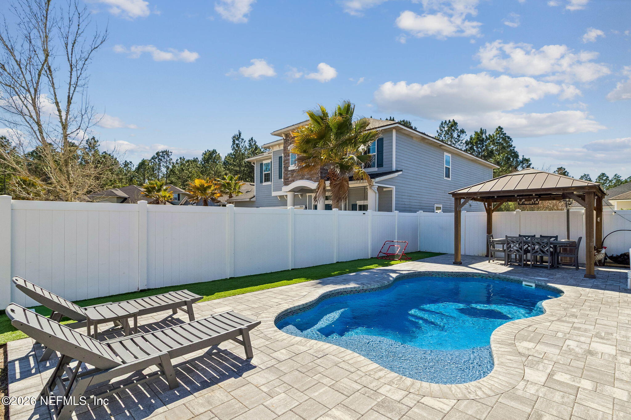 96048 Breezeway Court Yulee, FL 32097 - Photo 5 of 26 a swimming pool with yard and outdoor seating