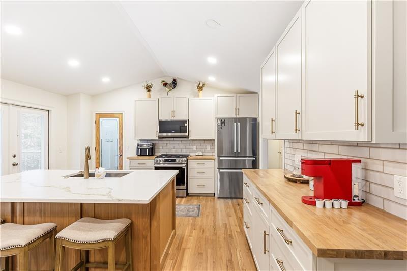 3890 Jim Owens Road Northwest Kennesaw, GA 30152 - Photo 13 of 43 a kitchen with stainless steel appliances kitchen island granite countertop a kitchen island and chairs in it