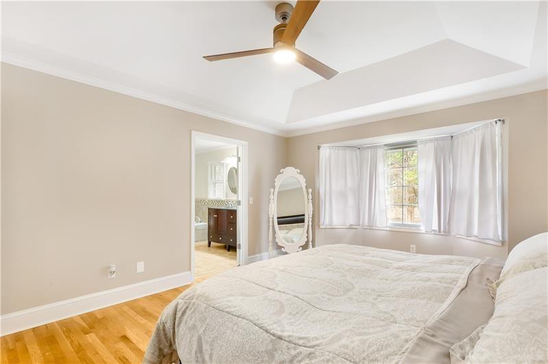3890 Jim Owens Road Northwest Kennesaw, GA 30152 - Photo 26 of 43 a spacious bedroom with a large bed and a chandelier