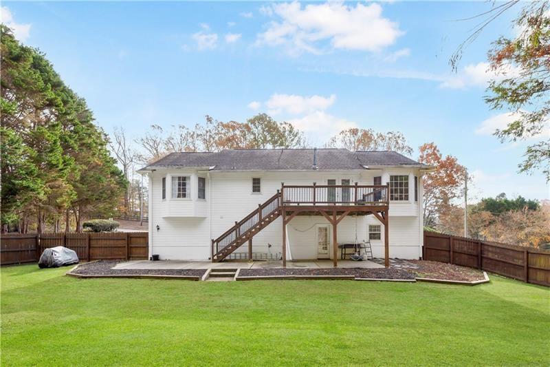 3890 Jim Owens Road Northwest Kennesaw, GA 30152 - Photo 42 of 43 a front view of a house with a garden and lake view