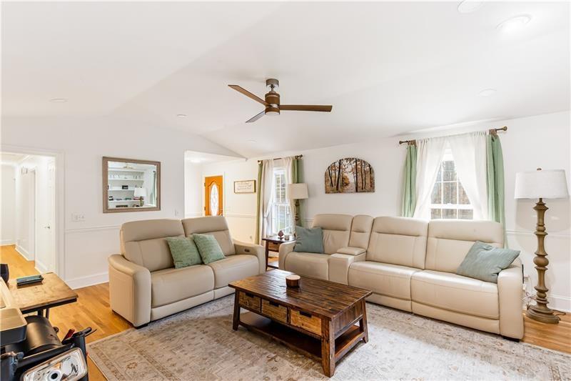 3890 Jim Owens Road Northwest Kennesaw, GA 30152 - Photo 7 of 43 a living room with furniture a rug and a ceiling fan