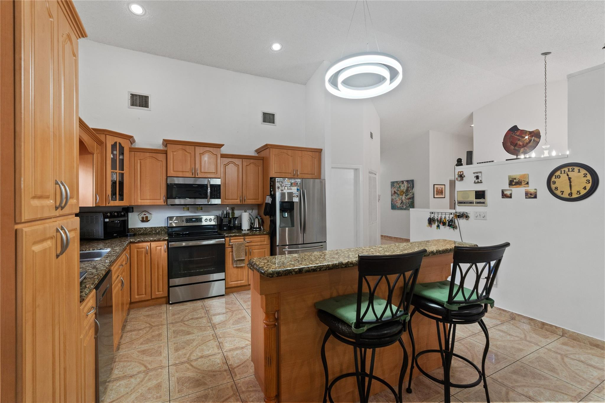 7440 Southwest 93rd Avenue Miami, FL 33173 - Photo 23 of 50 a kitchen with stainless steel appliances a dining table chairs and stove top oven