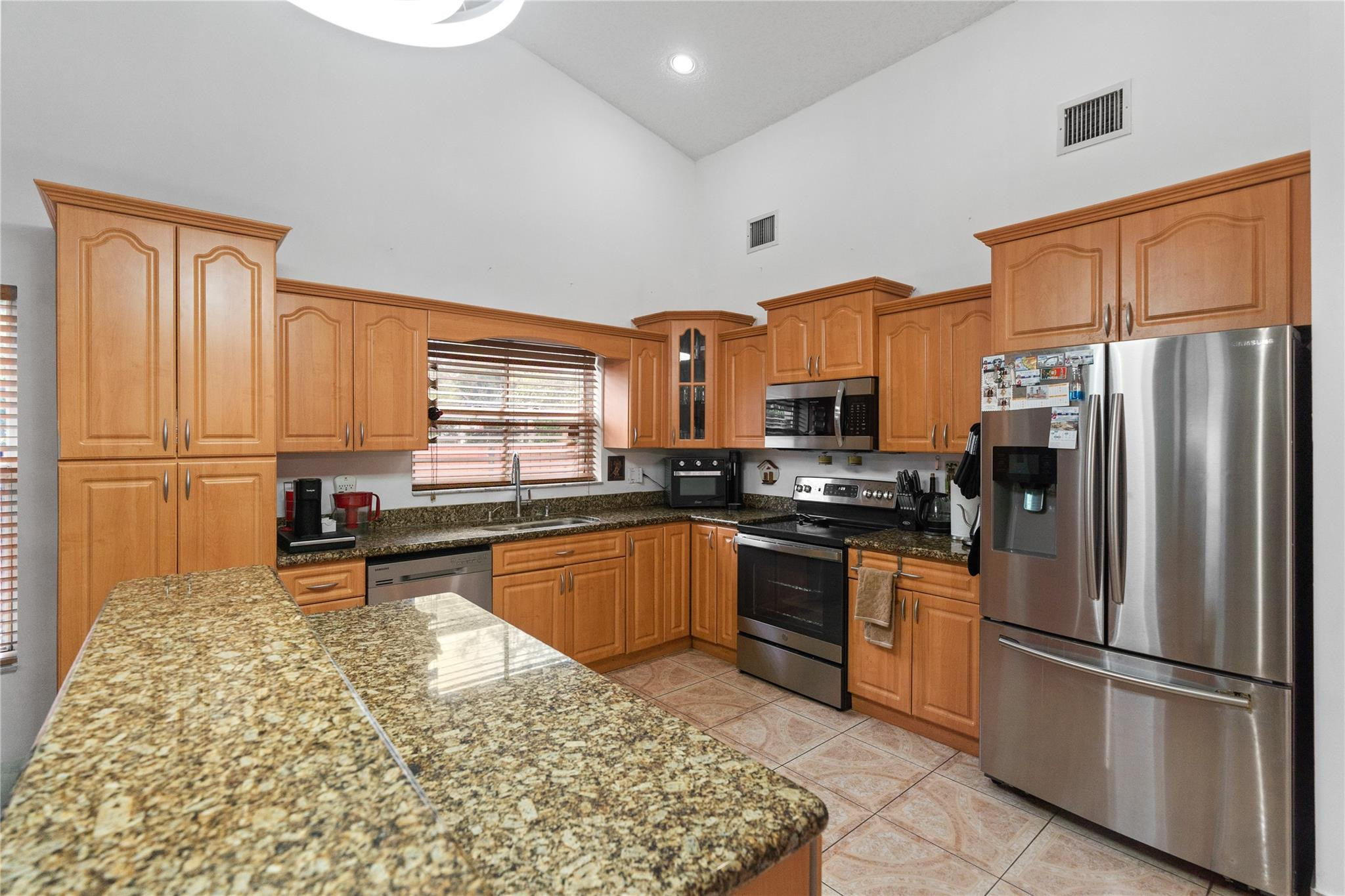 7440 Southwest 93rd Avenue Miami, FL 33173 - Photo 25 of 50 a kitchen with stainless steel appliances granite countertop a refrigerator sink and stove