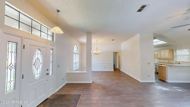 a view of a big room with wooden floor and windows