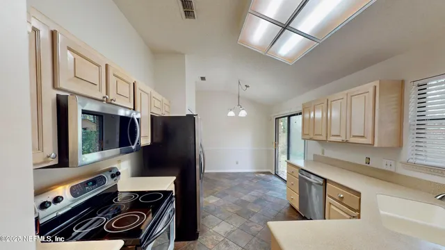 a kitchen with stainless steel appliances granite countertop a refrigerator and a stove