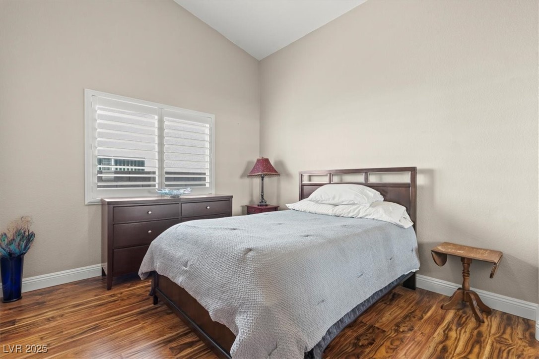 9031 West Viking Road Las Vegas, NV 89147 - Photo 23 of 33 Bedroom featuring vaulted ceiling, wood finished floors, and baseboards