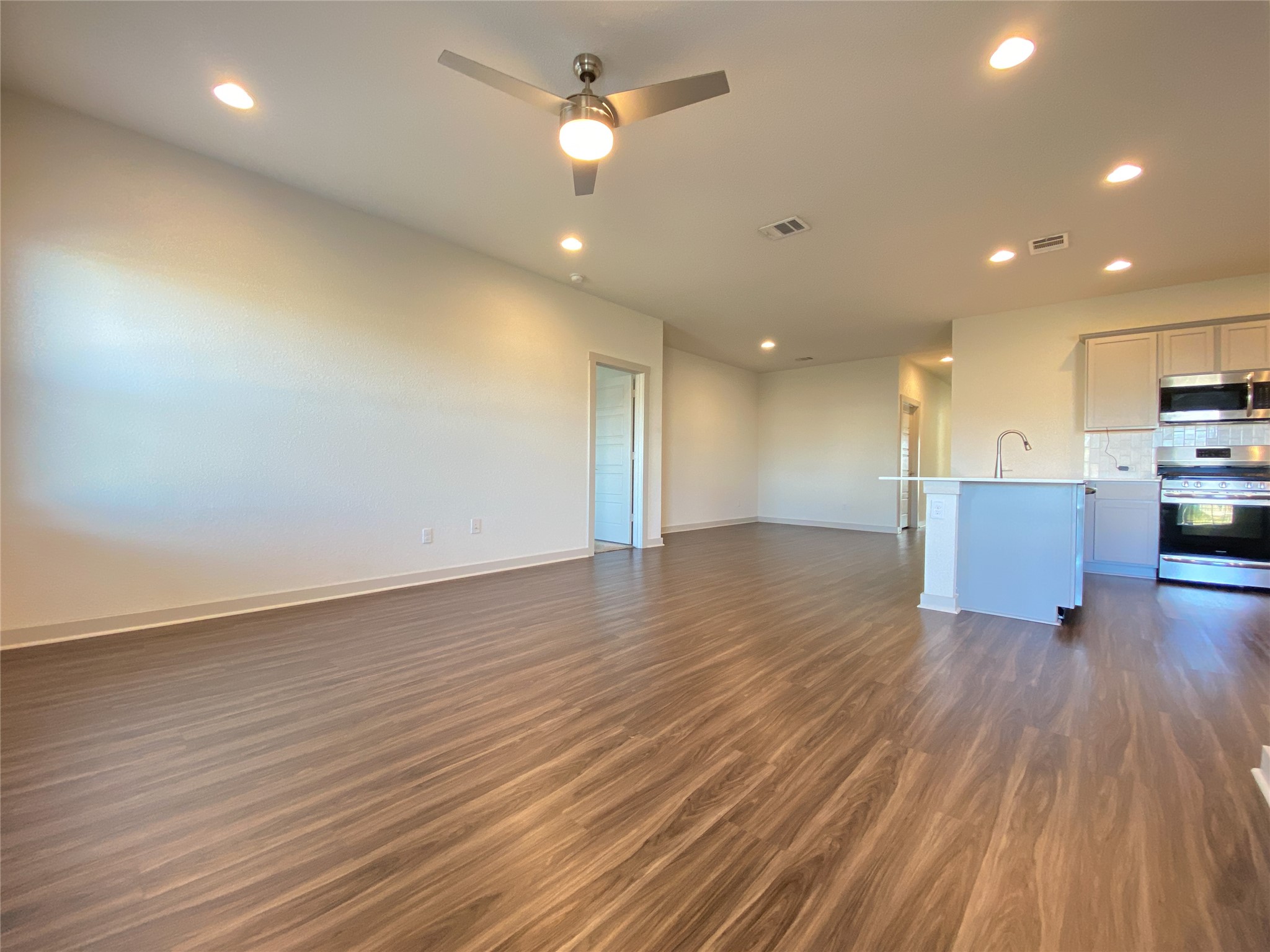 5121 Vanner Path Georgetown, TX 78626 - Photo 6 of 24 a view of kitchen and empty room with wooden floor