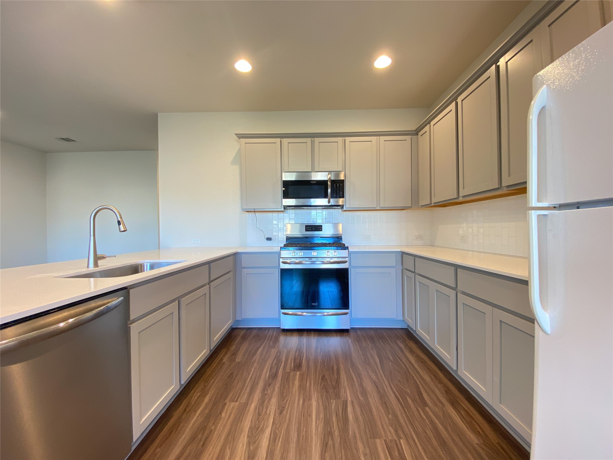 5121 Vanner Path Georgetown, TX 78626 - Photo 7 of 24 a kitchen with sink a stove and cabinets