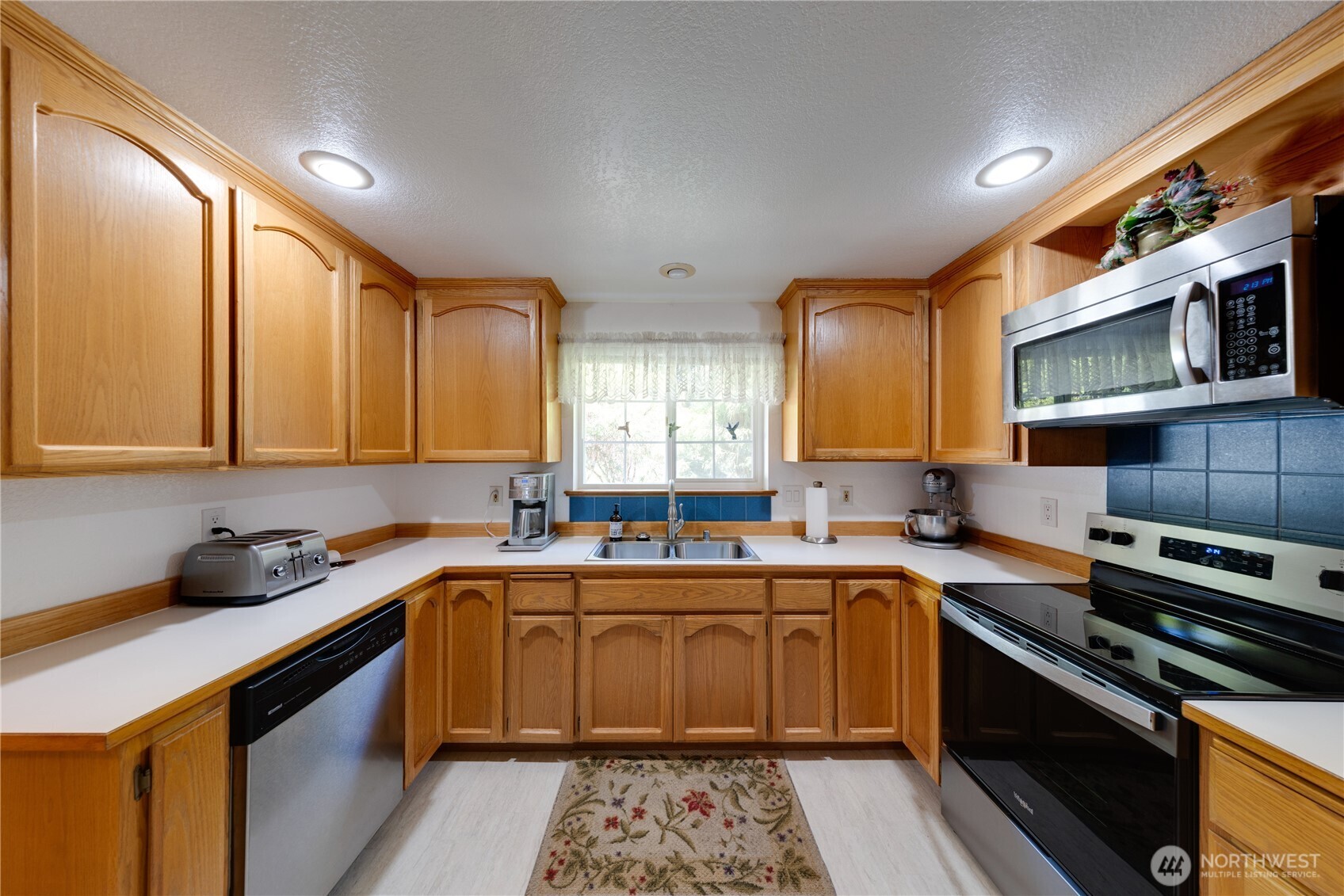 399 Tilingit Place La Conner, WA 98257 - Photo 14 of 39 a kitchen with a sink stove top oven and cabinets
