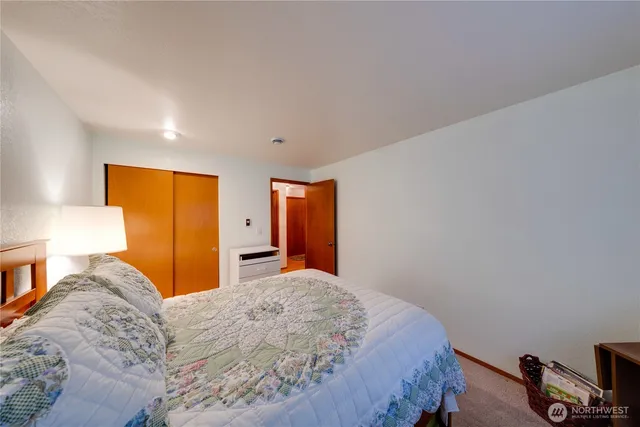 a bedroom with a bed and a flat tv screen on dresser
