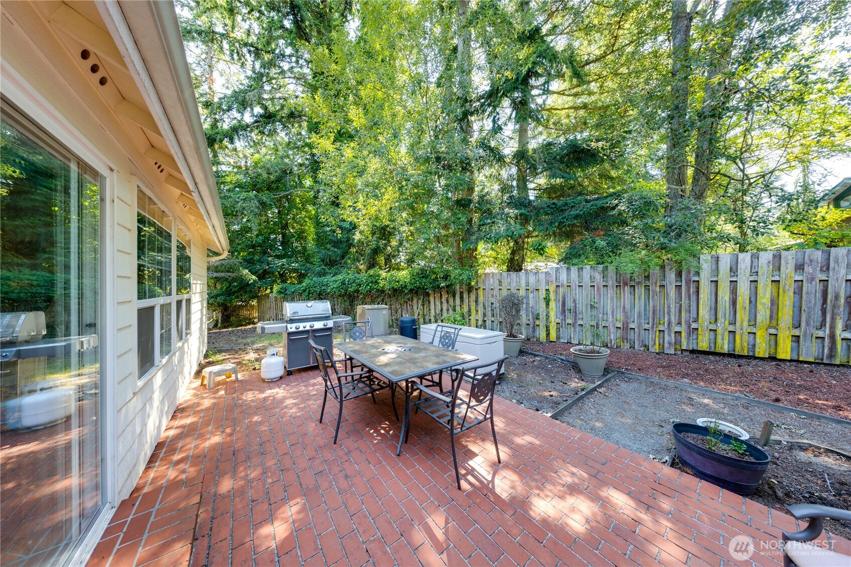 399 Tilingit Place La Conner, WA 98257 - Photo 29 of 39 a view of a patio with table and chairs and potted plants with wooden fence