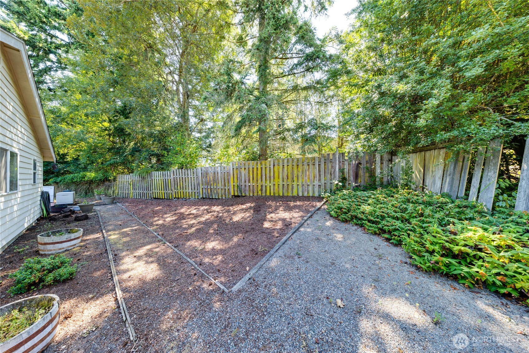 399 Tilingit Place La Conner, WA 98257 - Photo 30 of 39 a view of a backyard with plants and large trees