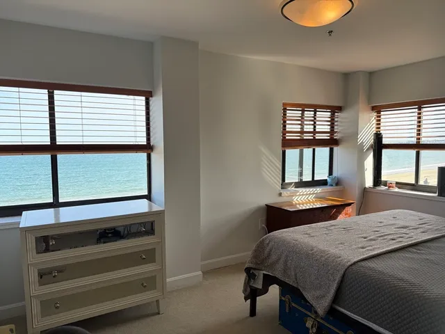 a bedroom with a bed and large windows