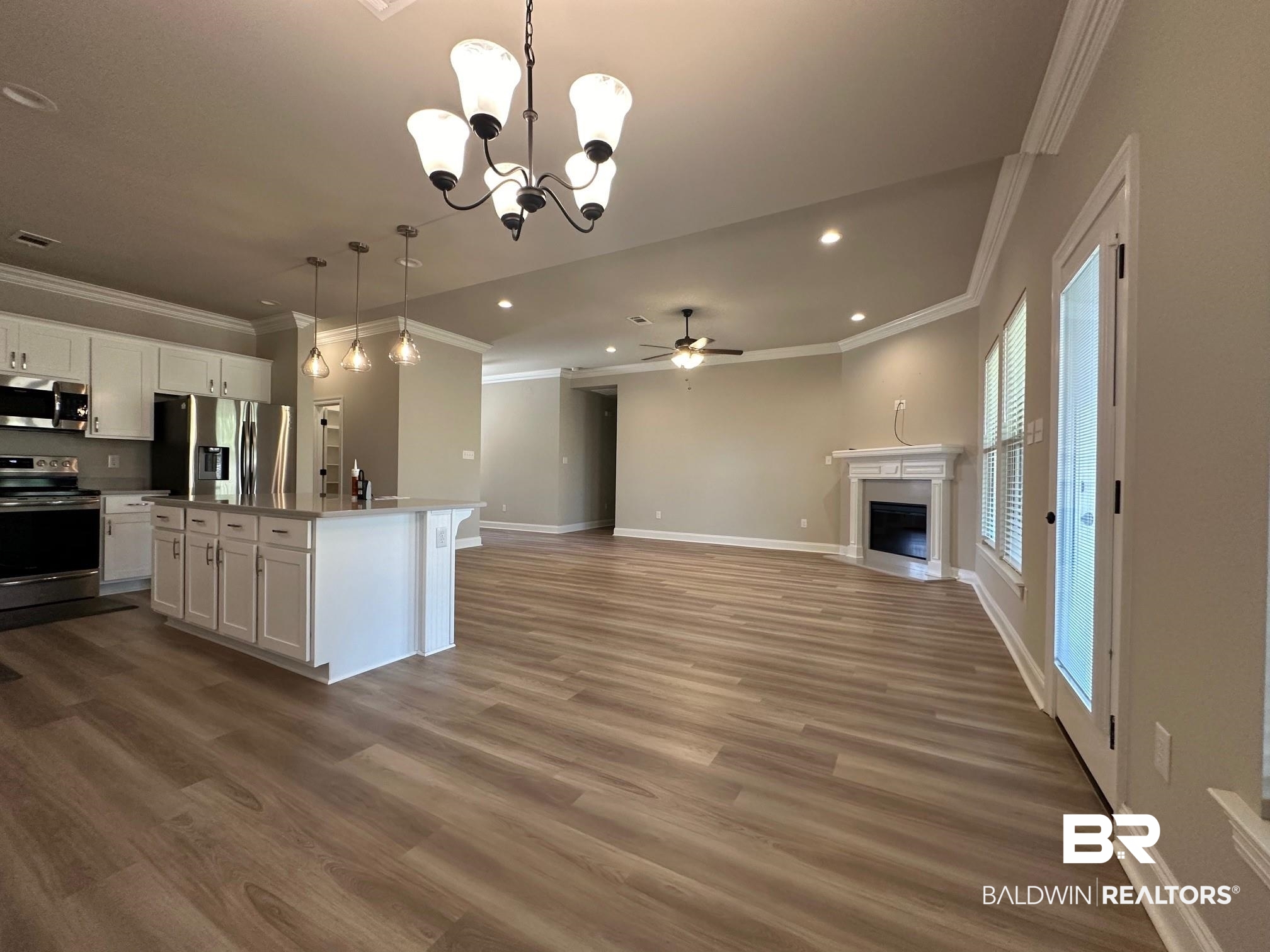 1009 Ruisseau Drive Foley, AL 36535 - Photo 35 of 55 Kitchen featuring appliances with stainless steel finishes, an island with sink, hardwood / wood-style floors, and white cabinets