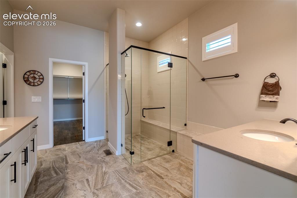 1061 Native Dancer Terrace Colorado Springs, CO 80921 - Photo 26 of 50 Contemporary bathroom with a glass-enclosed shower featuring a built-in bench