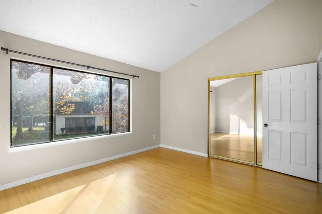 a view of empty room with wooden floor and fan