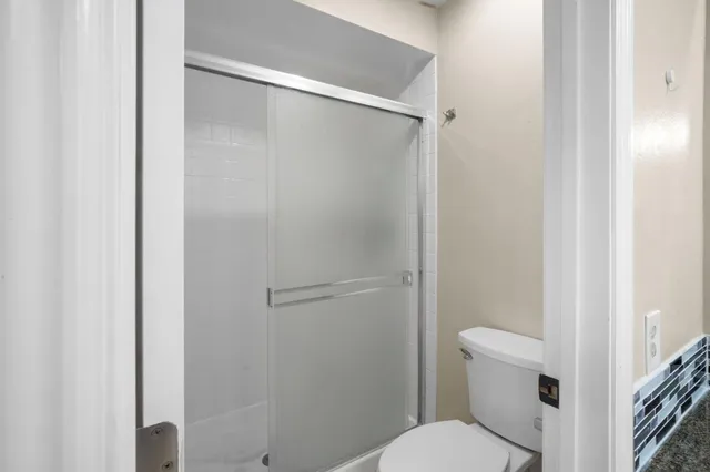 a white toilet sitting next to a shower