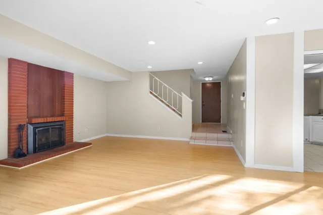 a view of an empty room with a fireplace and a window