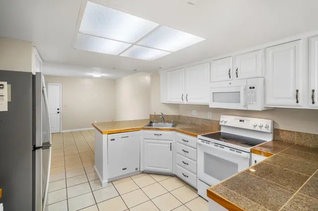 a kitchen with white cabinets appliances and sink