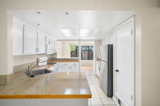 a large white kitchen with a large window
