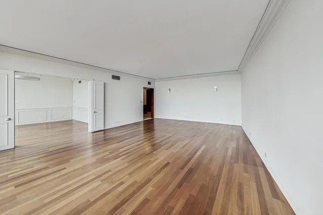a view of an empty room with wooden floor